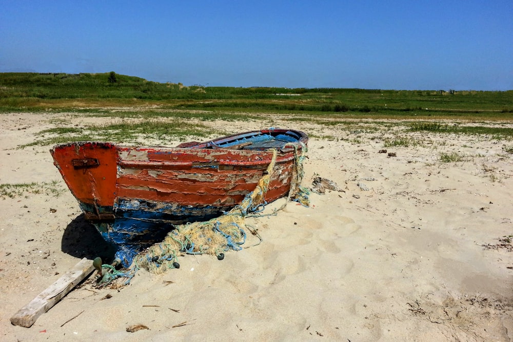 a boat sitting on top of a sandy beach