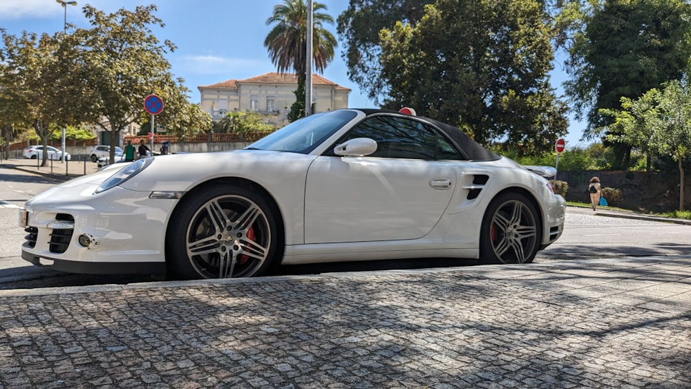 a white sports car parked on the side of the road