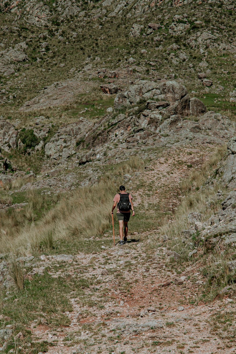 a person walking up a hill with a backpack