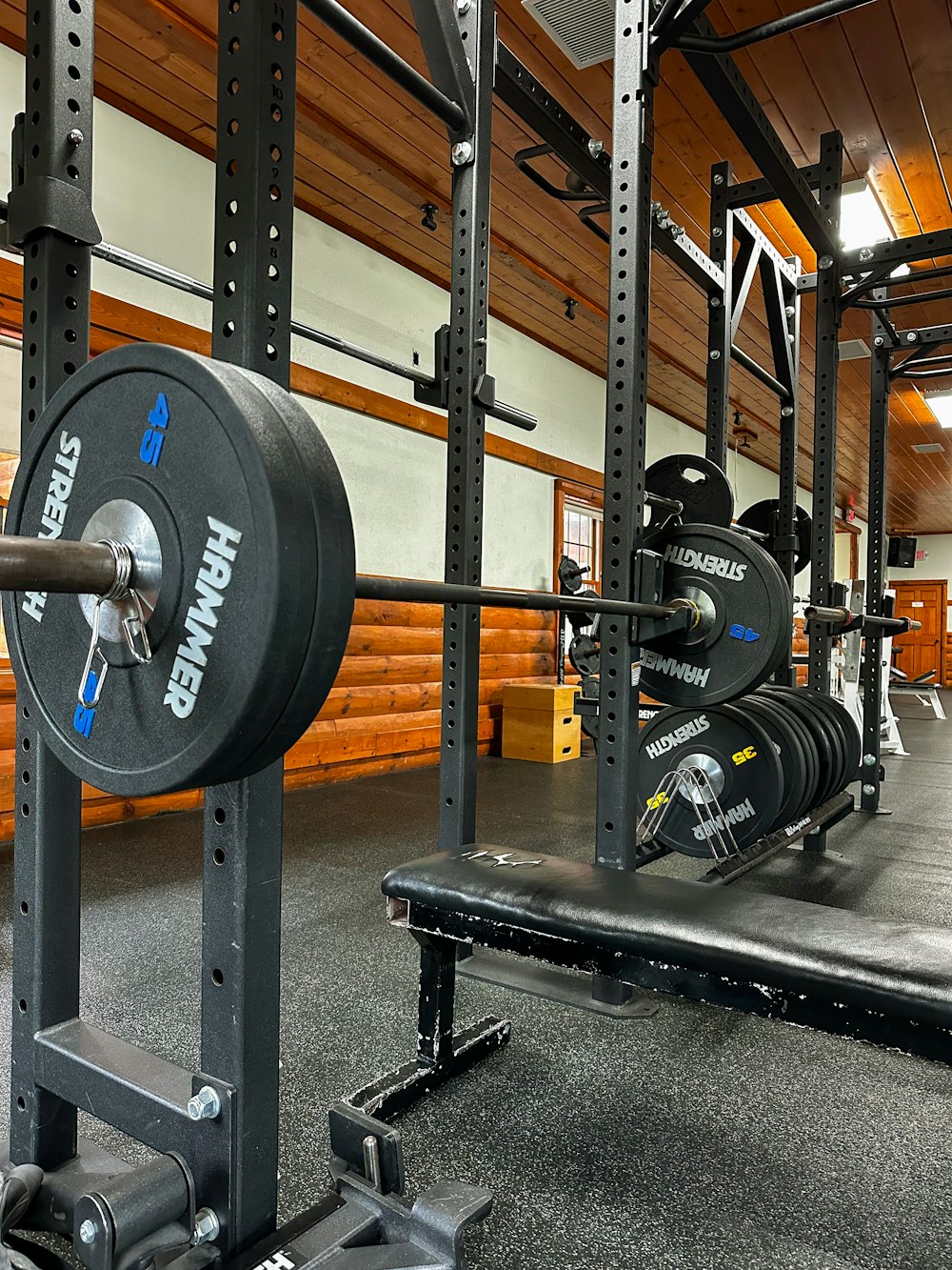 a gym with a bench, weight plates and barbells