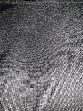 A charcoal-gray textile piece with subtle ember threads glowing faintly.