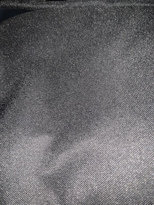 Detail shot of the Nordic Pulse k-way’s fabric highlighting the grey and black matte finish under soft light.