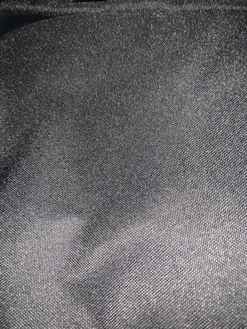 Close-up of premium breathable fabric in charcoal grey with subtle metallic silver threads.