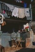 A serene scene of a sunny porch with clothing pieces hanging to dry, swaying gently.
