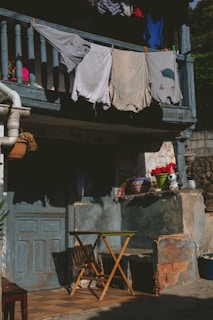 A cozy porch with a soft pink laundry bag waiting by the front door on a sunny morning.