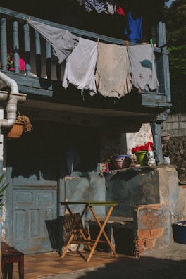 A serene scene of a sunny porch with clothing pieces hanging to dry, swaying gently.
