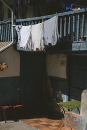 a clothesline hanging on a balcony next to a chair