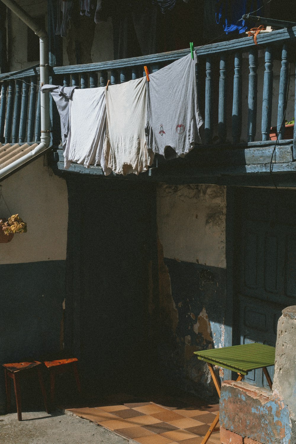 a clothesline hanging on a balcony next to a chair