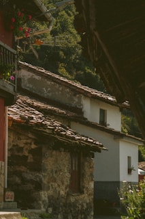an old stone building with a balcony and flowers on the roof
