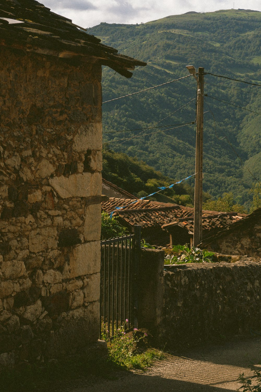 a stone building sitting next to a lush green hillside