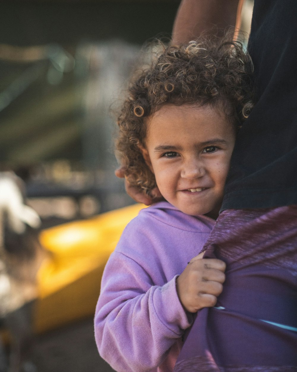 a little girl that is holding on to her mother