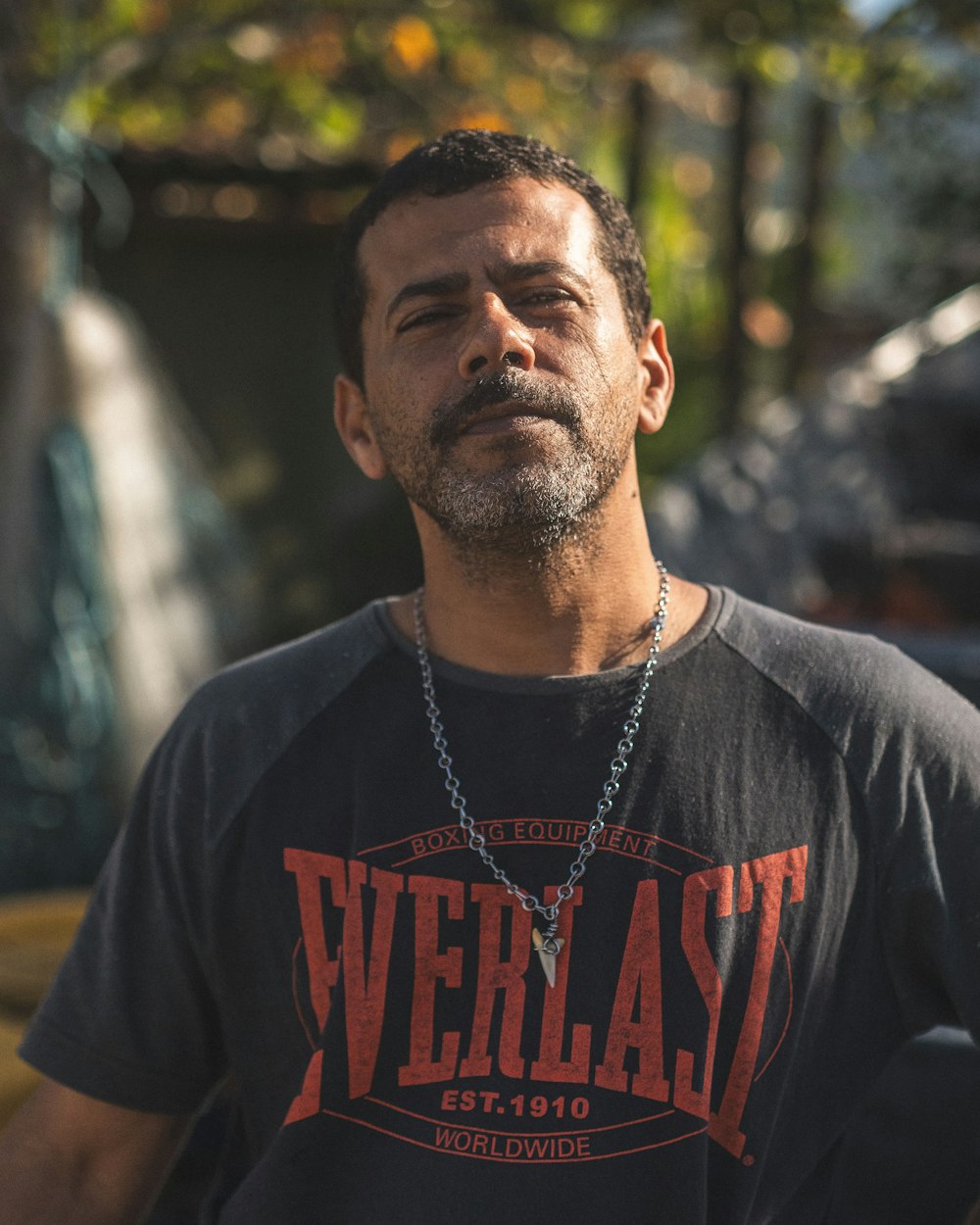 a man wearing a black shirt and a chain around his neck