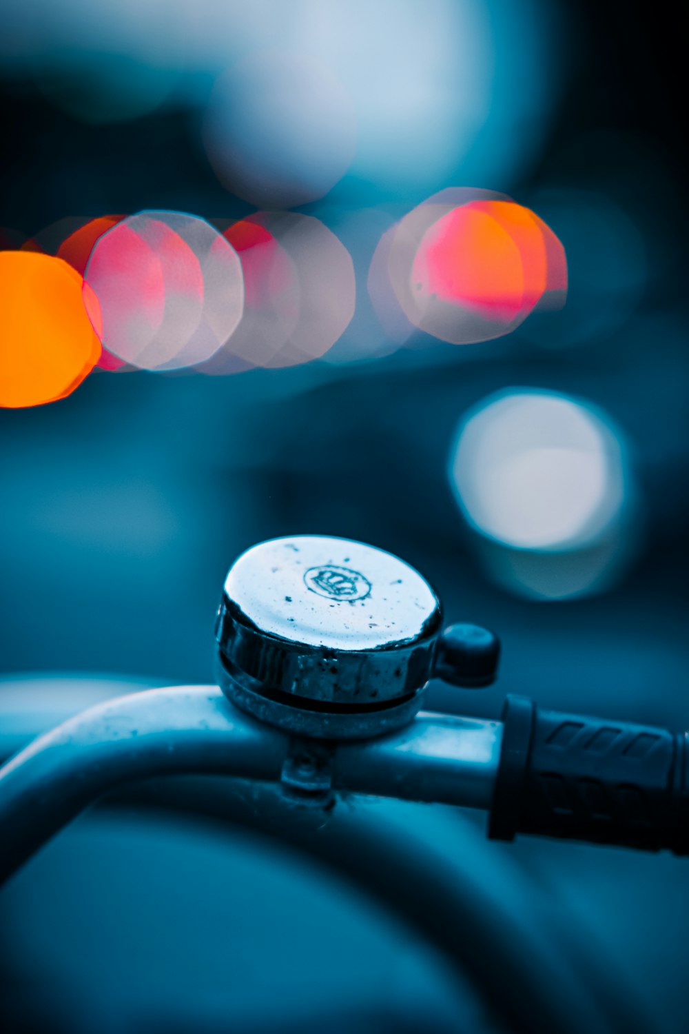 a close up of a bike handlebar with blurry lights in the background