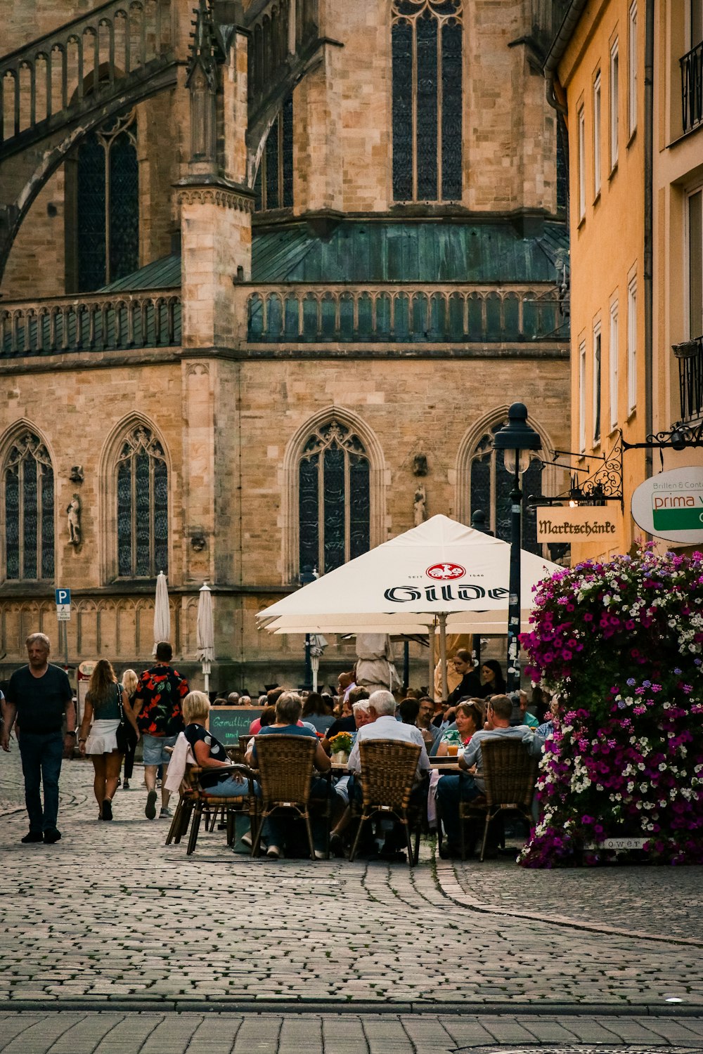 a group of people sitting at tables in front of a building