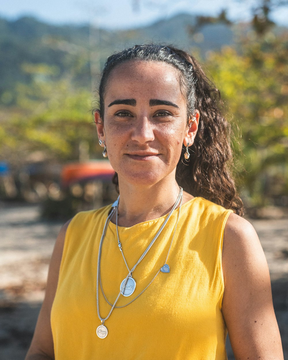 a woman wearing a yellow shirt and a necklace