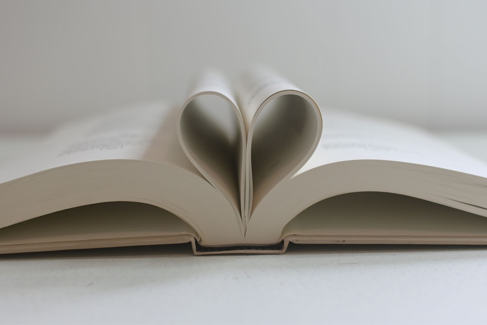 an open book with a heart cut out of it