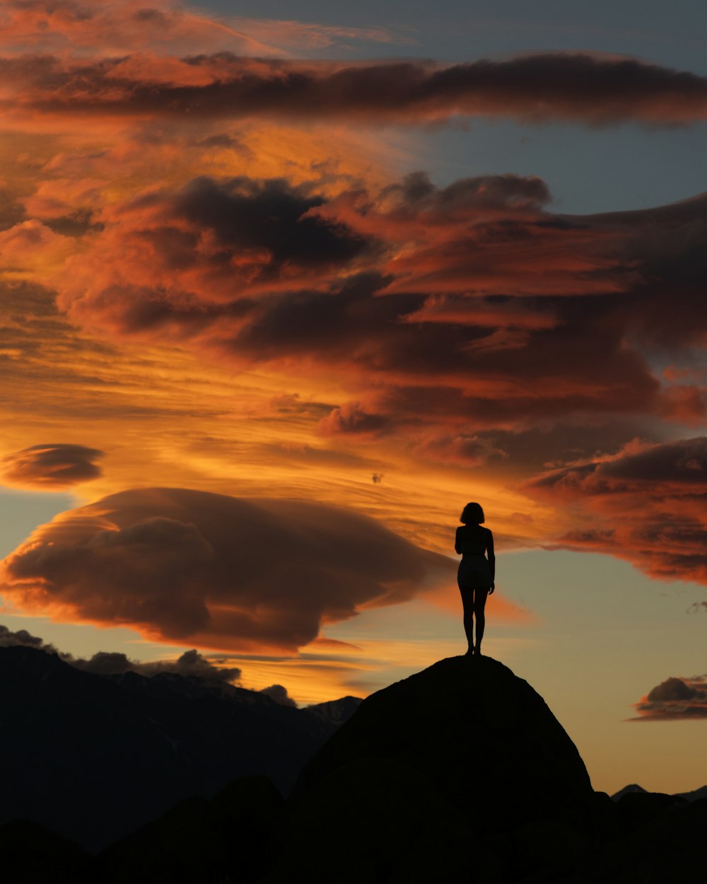 a person standing on top of a mountain at sunset