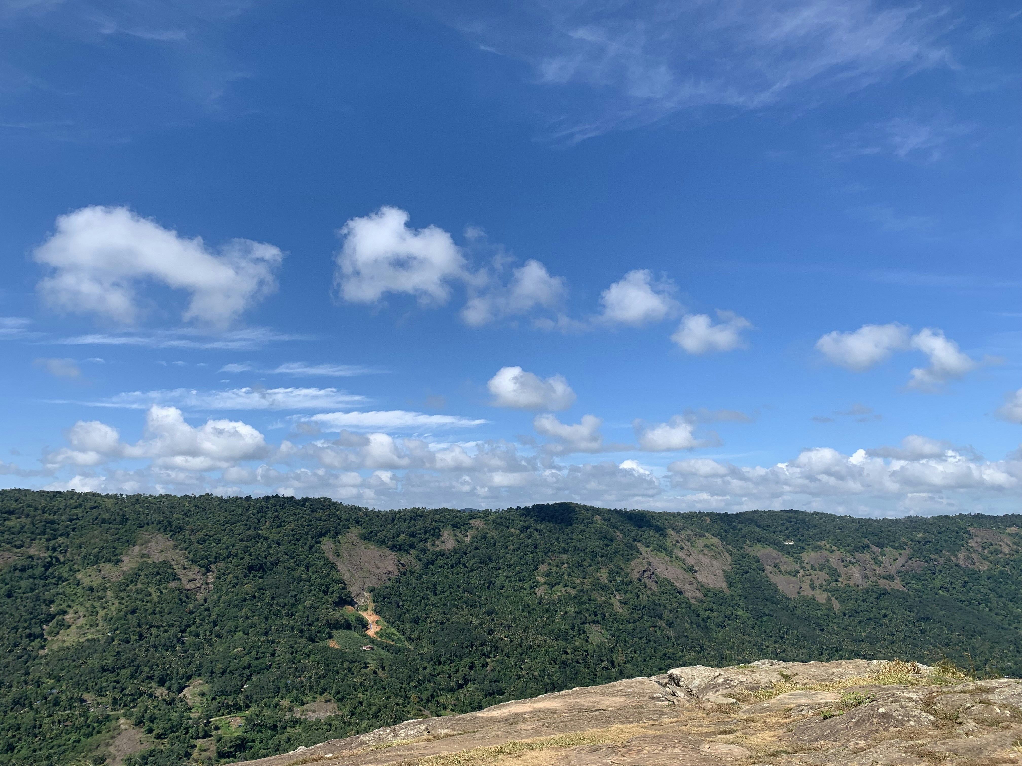uma pessoa em pé no topo de uma montanha com um fundo de céu