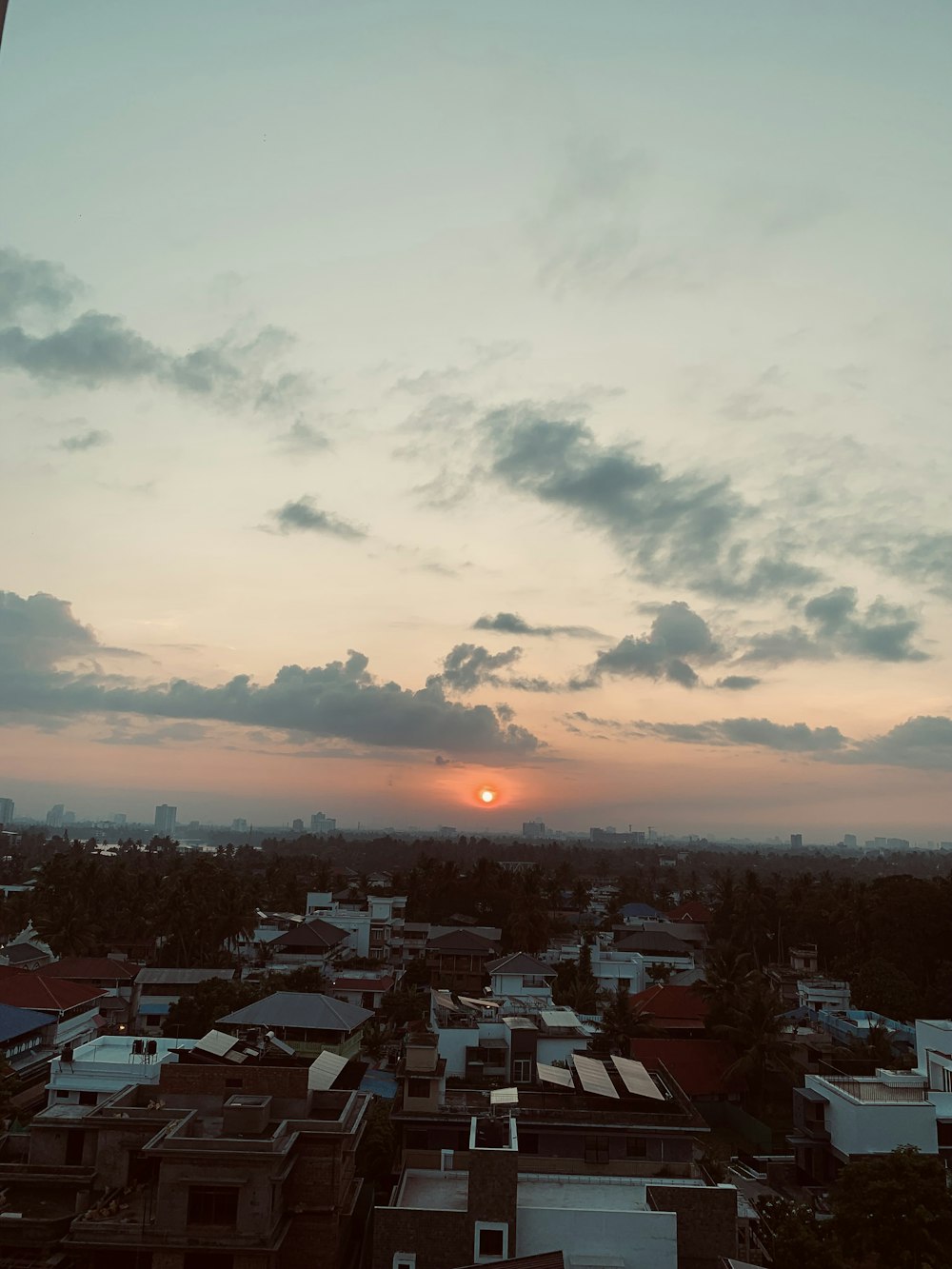 the sun is setting over a city with tall buildings