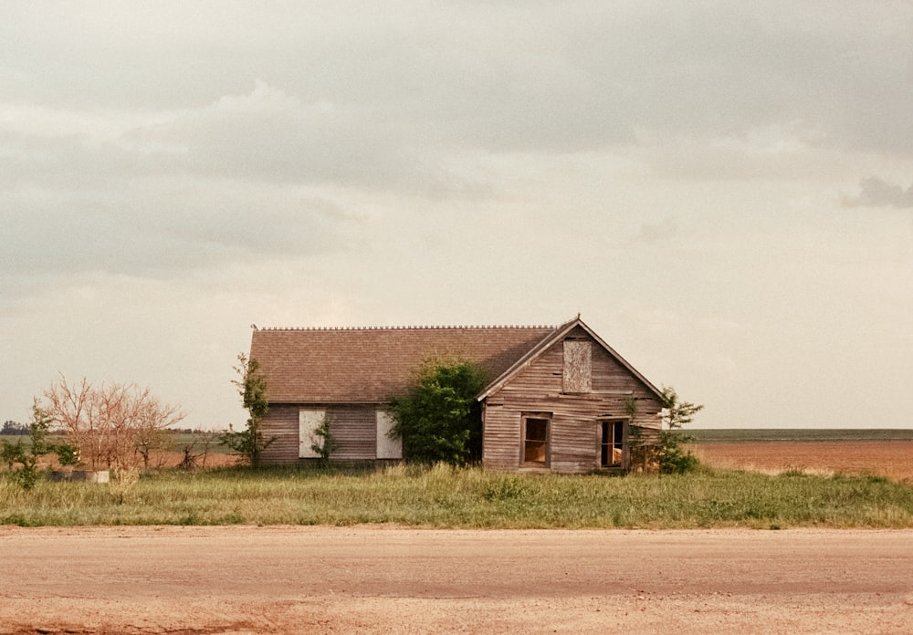 an old run down house in the middle of a field