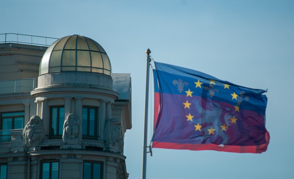 a european and european flag flying in front of a building