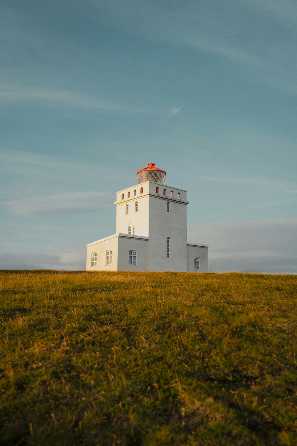 a large white building sitting on top of a lush green field