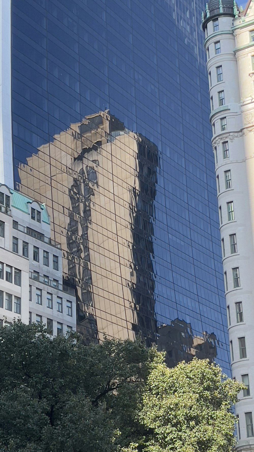 a tall building with a reflection of another building in it