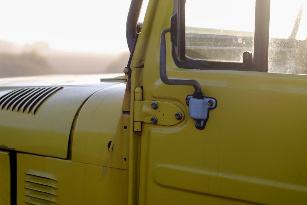 a close up of the door of a yellow truck