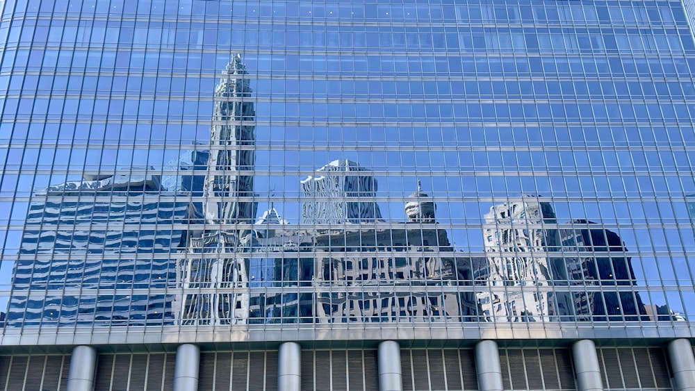 a large building is reflected in the windows of another building