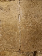 A clear photo showing a note folded and tucked securely inside the Western Wall stones.