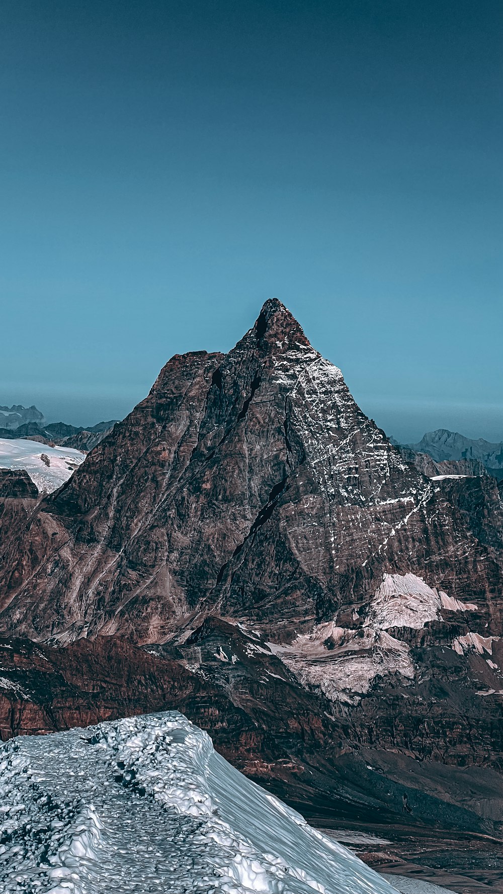 a snow covered mountain with a blue sky in the background