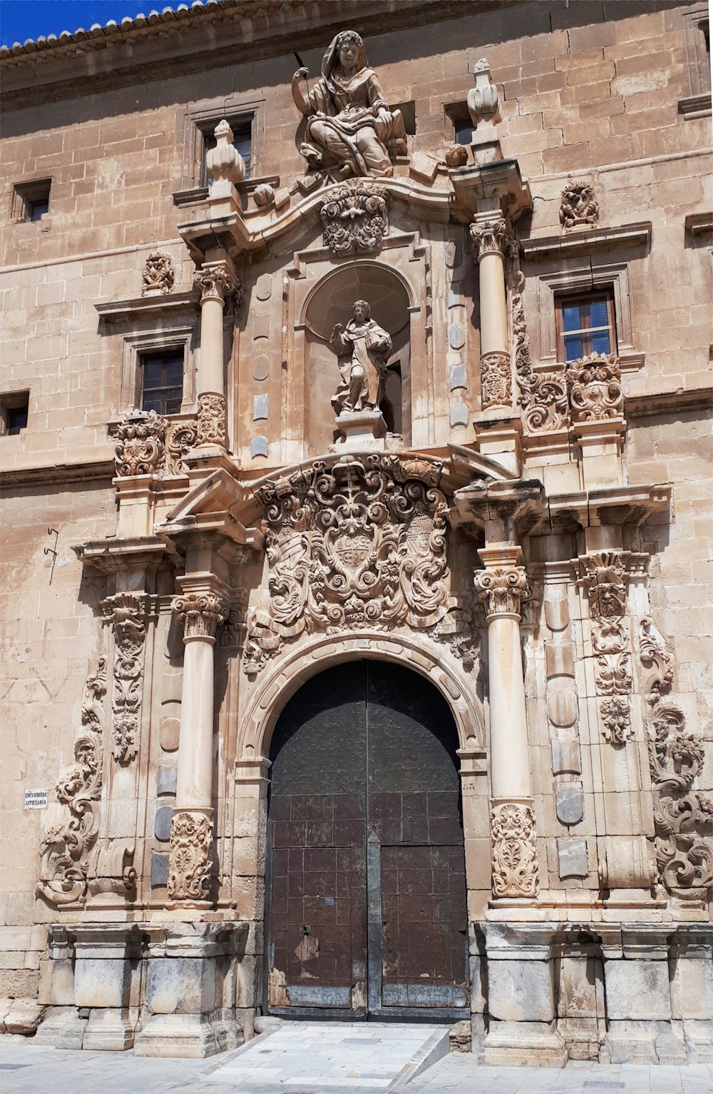 a large building with a large doorway and a clock on the front of it