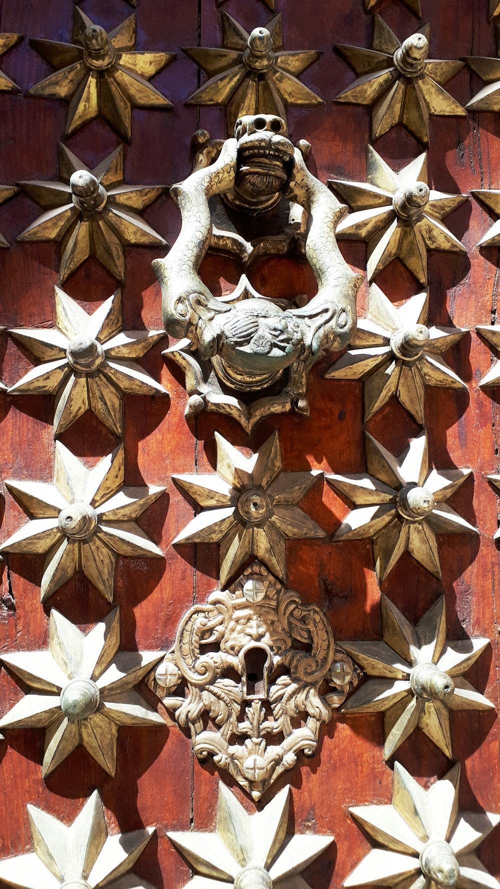 Un primer plano de una puerta de madera con decoraciones metálicas