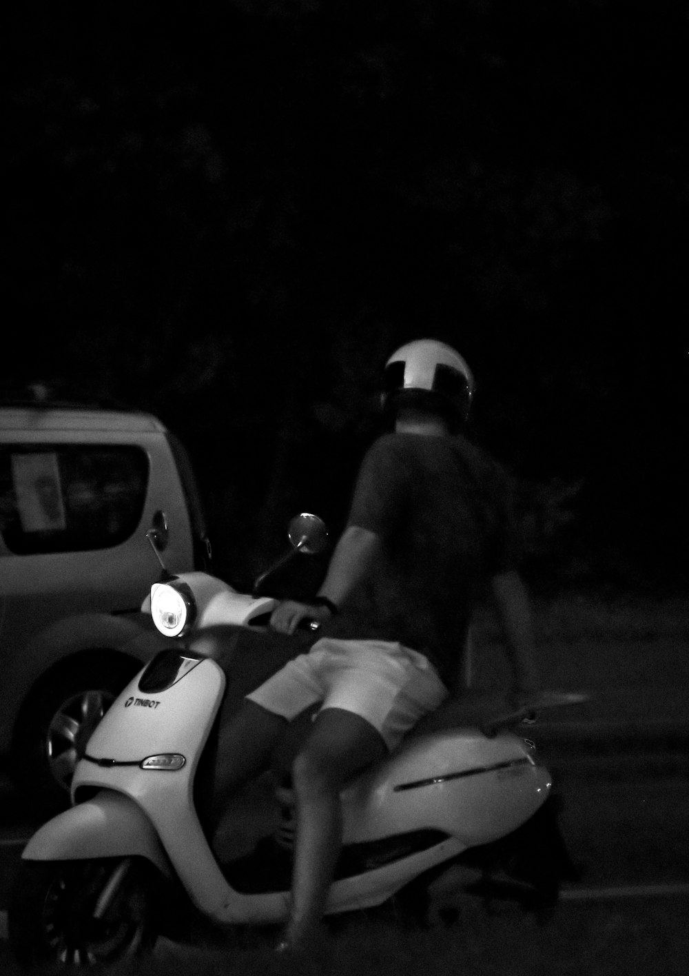 a man riding on the back of a white scooter