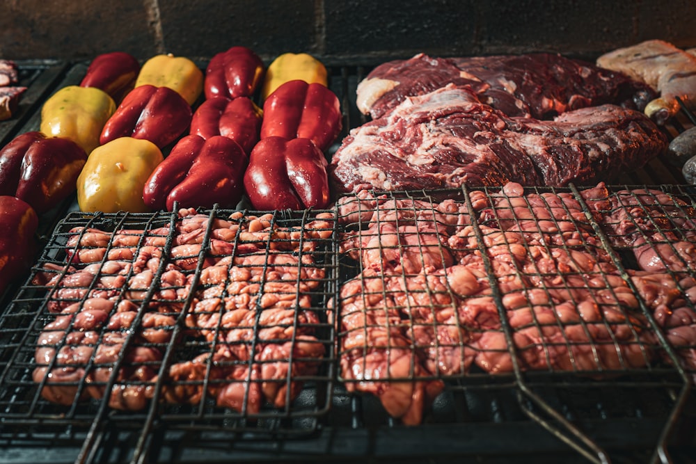 a bunch of meats and vegetables cooking on a grill