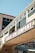 A commercial building facade with large windows and a prominent sign reading 'CANNERY ROW COMPANY'. The architecture features a beige exterior with glass panels and an overhanging structure. Underneath, there are additional storefront signs with various brand names like Coca-Cola.