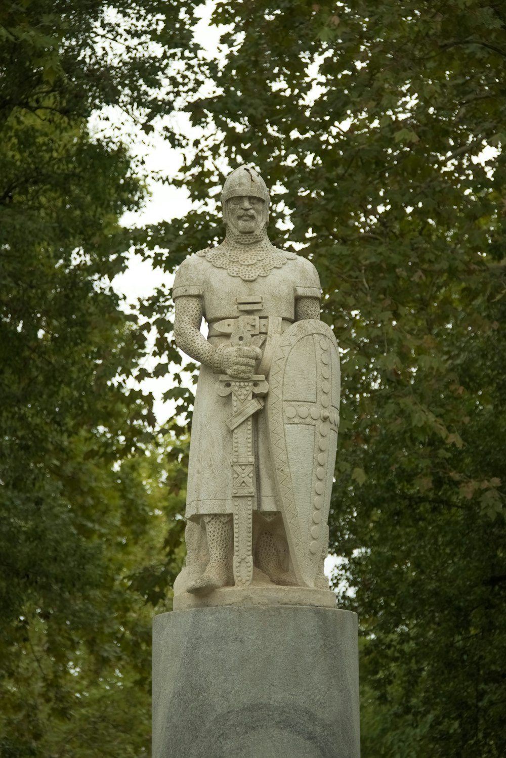 a statue of a man holding a shield and a shield