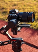 A high-end Sony camera mounted on a DJI Ronin gimbal, positioned outdoors on a track or pathway with grass in the background. The camera setup suggests professional-grade equipment used for capturing high-quality images or videos.