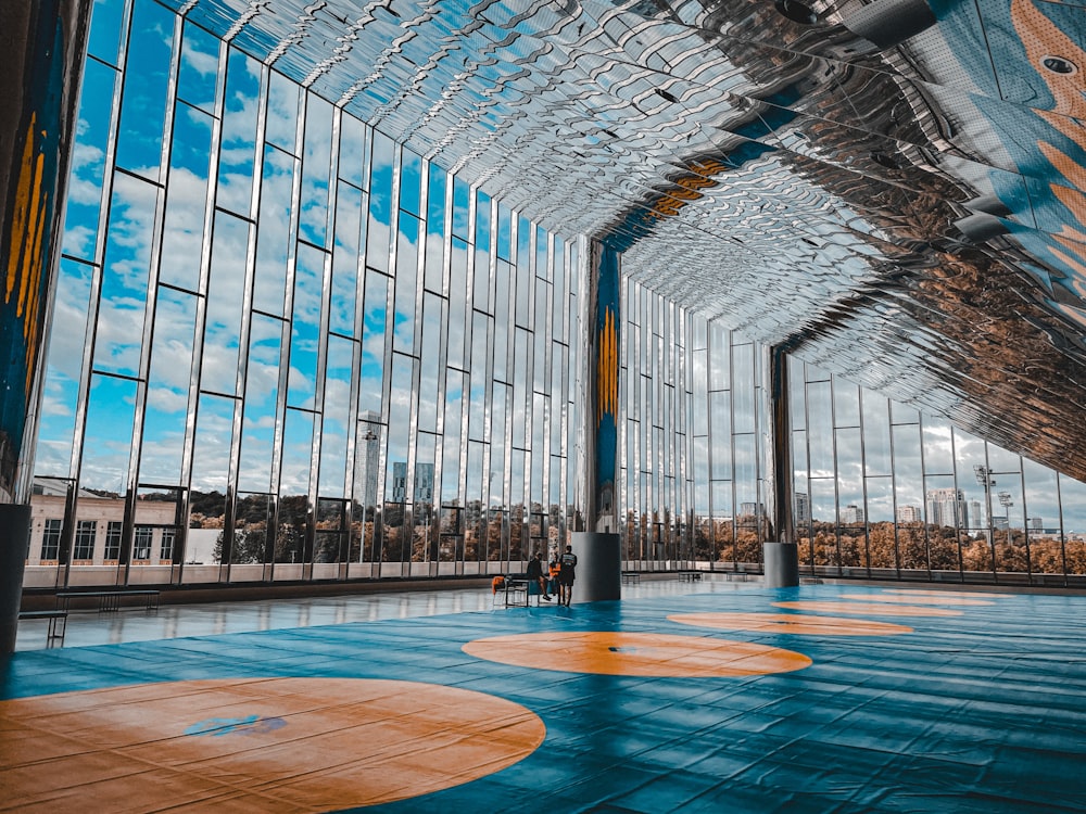 a person standing in a large building with a basketball court