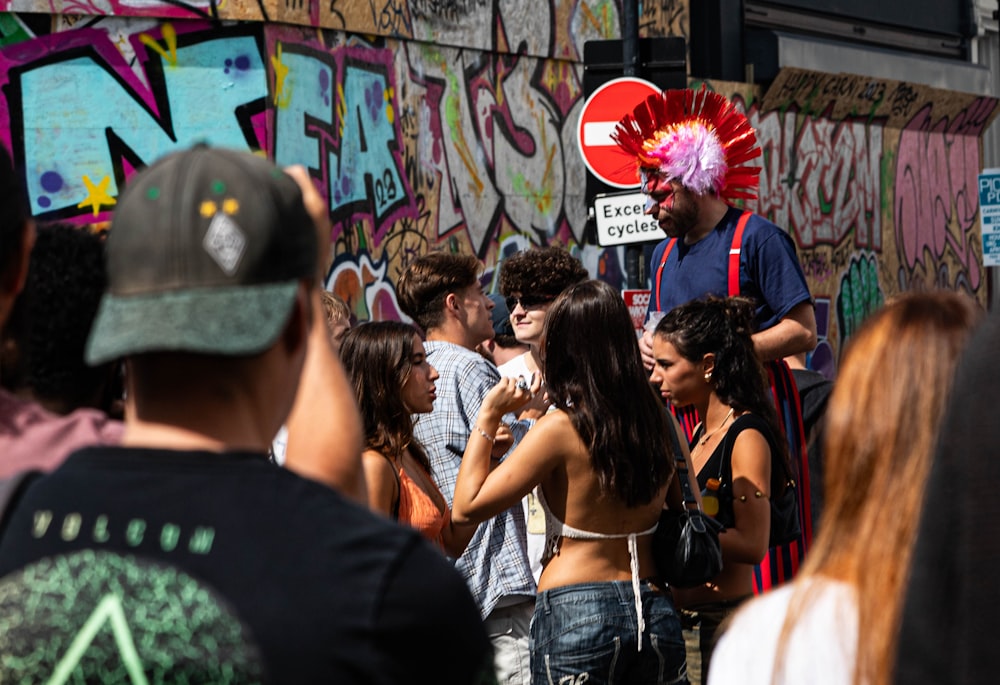 a group of people standing in front of a wall covered in graffiti