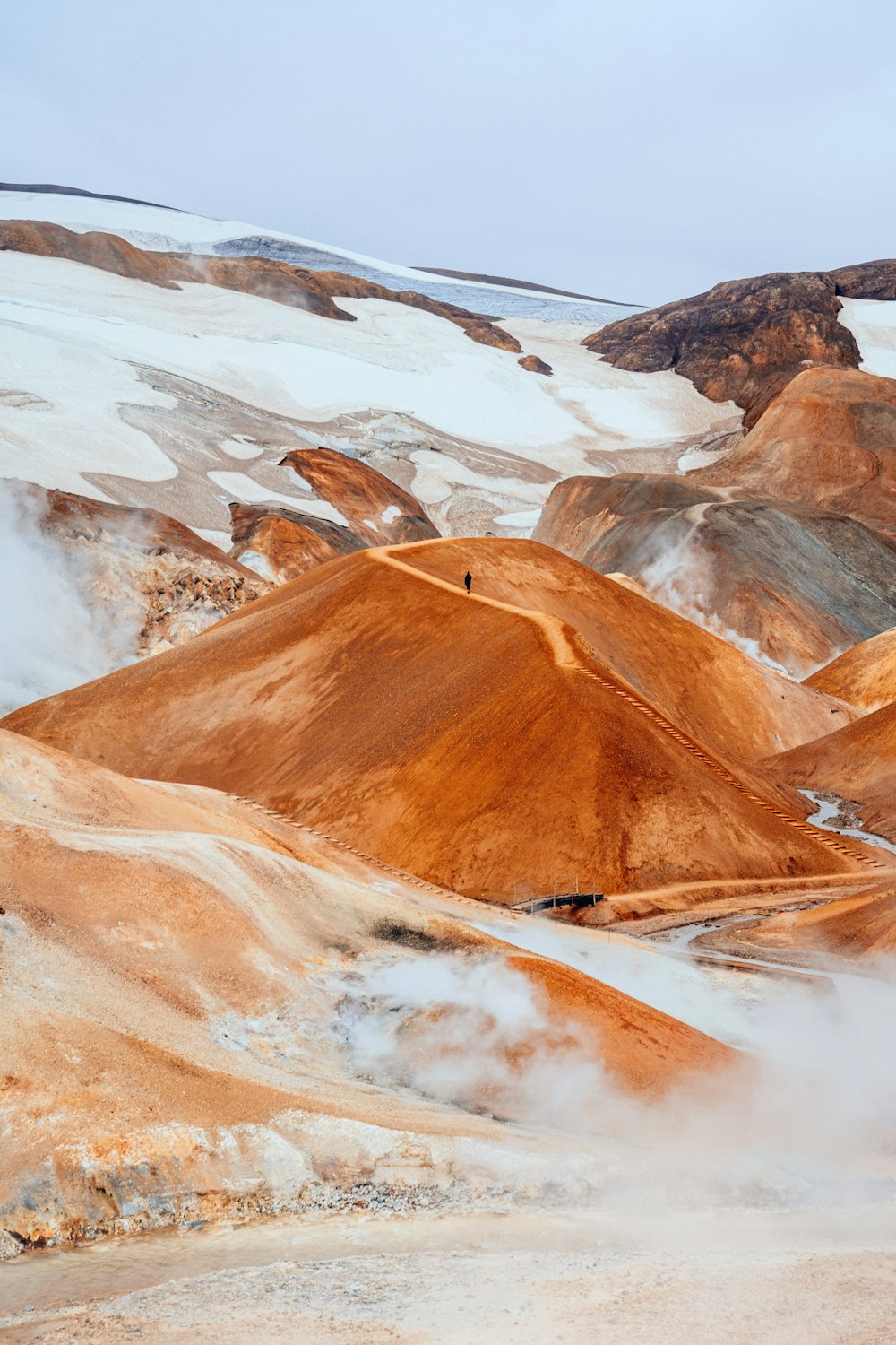 a group of mountains covered in snow and steam