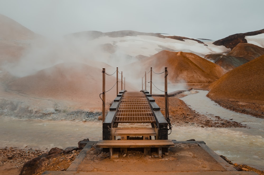 a wooden bridge over a stream of water