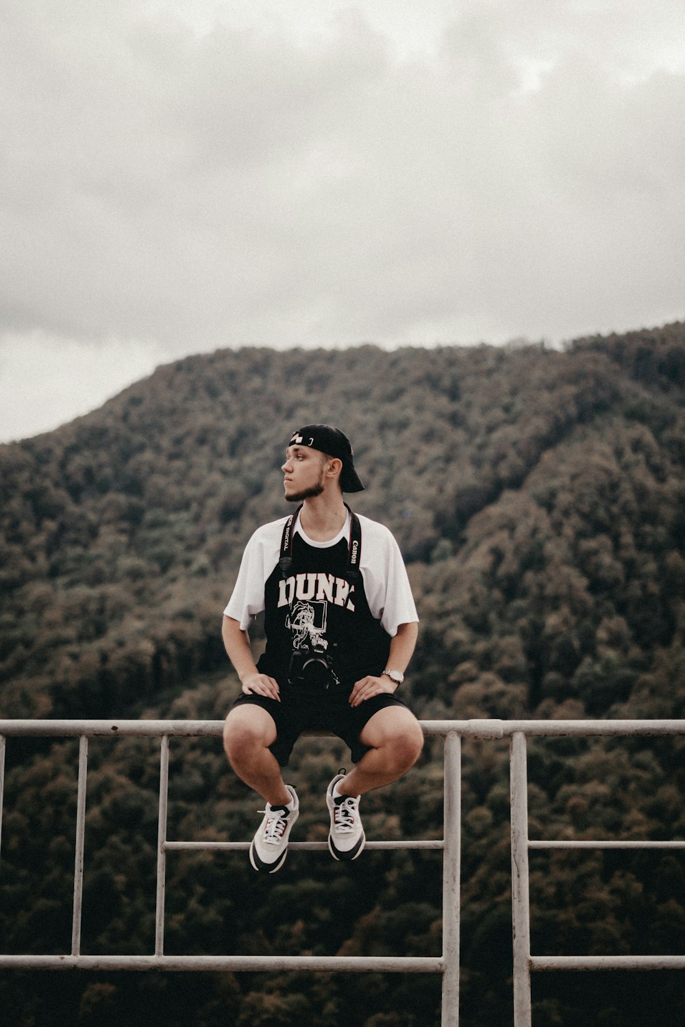 a man sitting on top of a metal railing