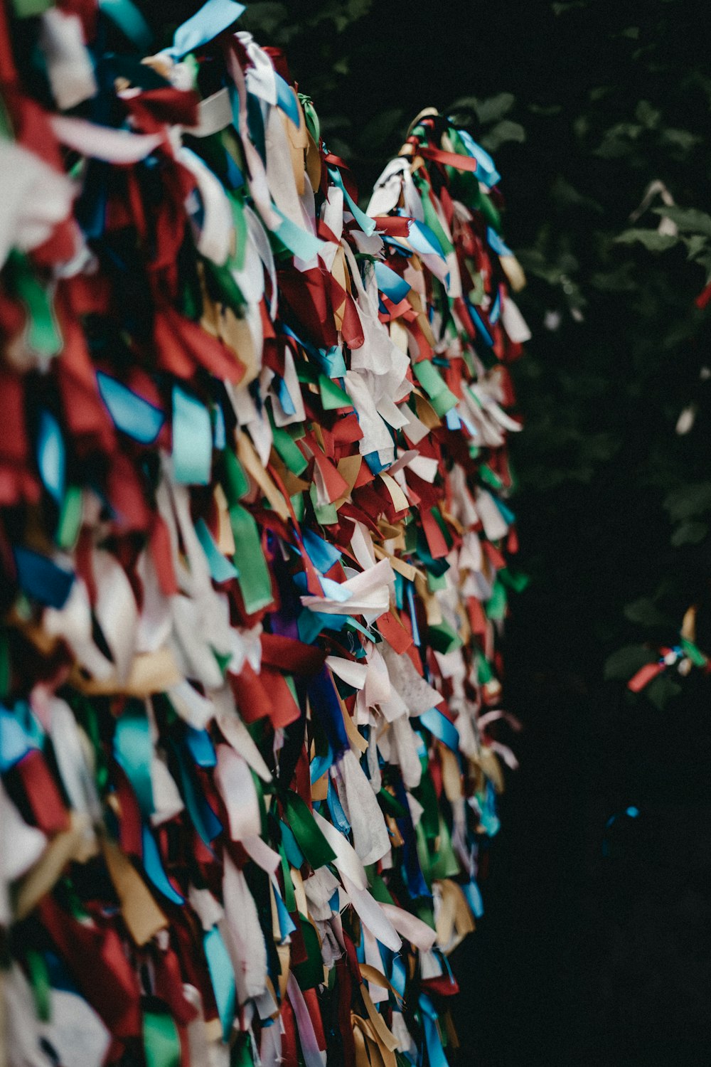 a bunch of colorful streamers hanging from a tree