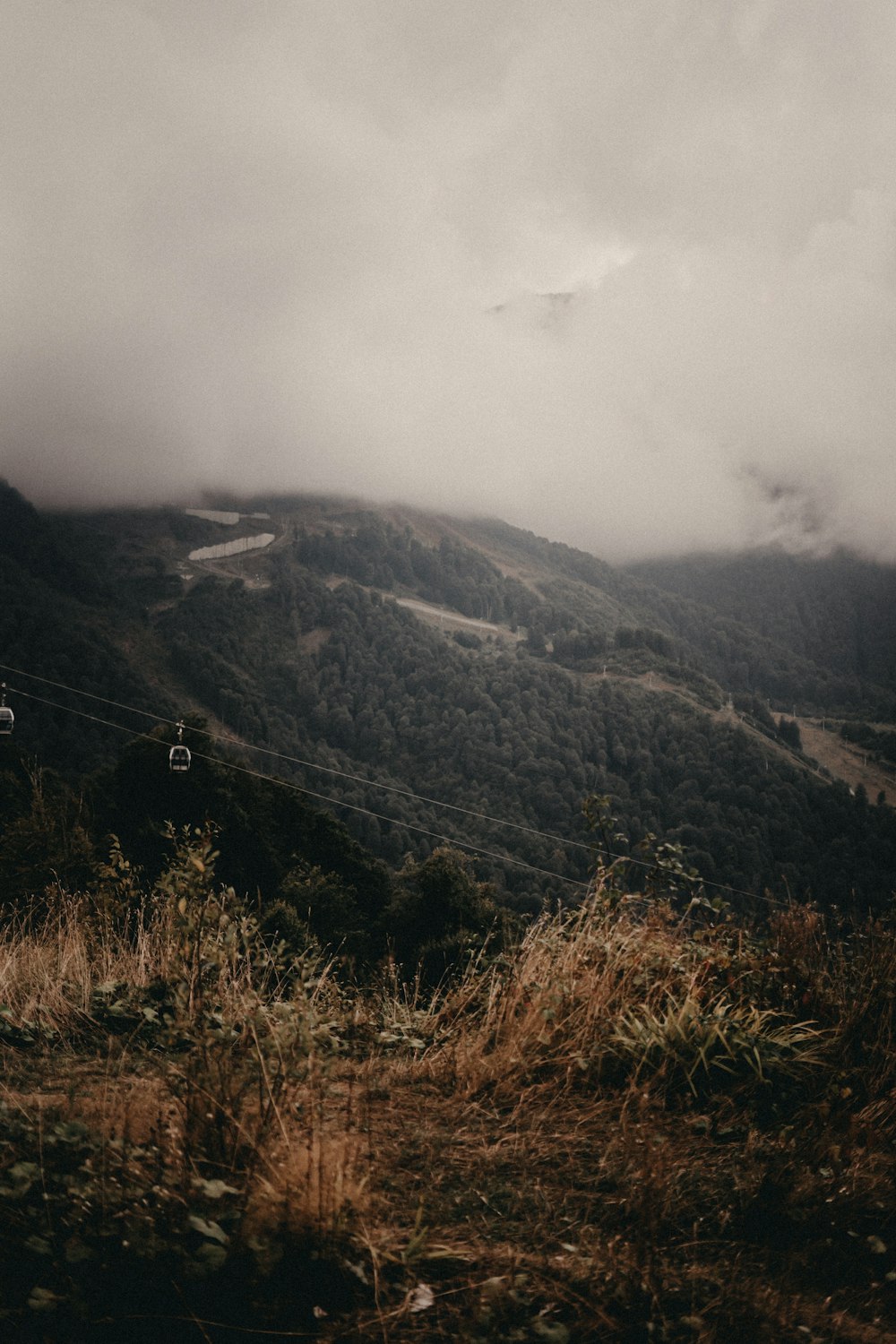 a couple of people riding a ski lift up a hill