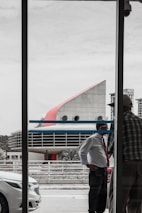 An architect and builder discussing a building project in front of a modern office backdrop.