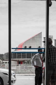 An architect and builder discussing a building project in front of a modern office backdrop.
