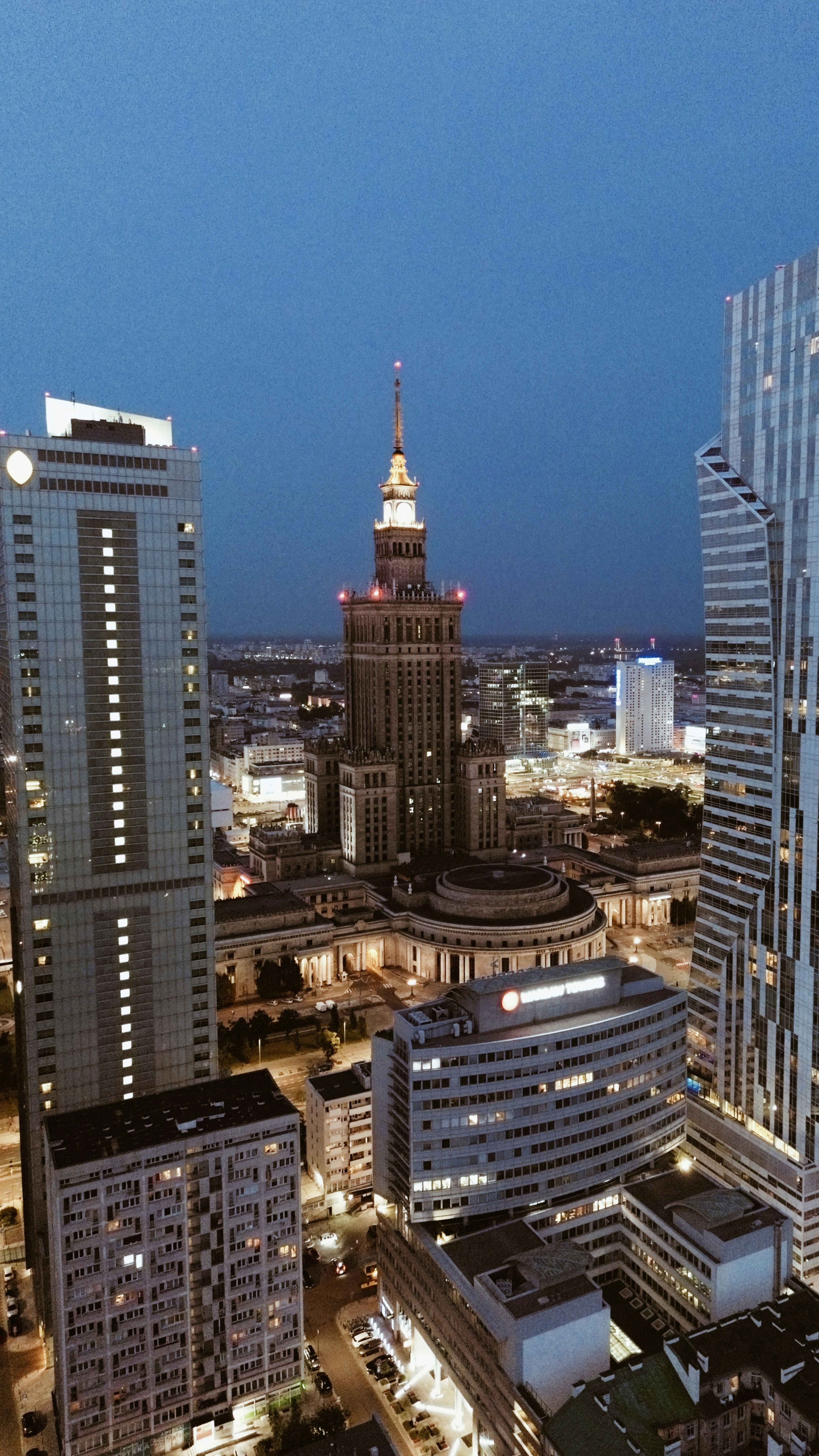 Luxury residential tower at dusk with dramatic dark sky and deep shadows