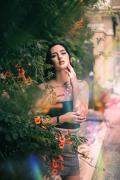 a woman standing in front of some flowers