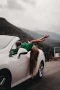 a woman leaning on the side of a white car